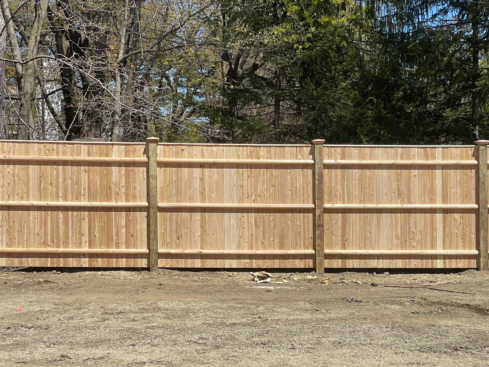 New cedar privacy fence built along a property line by 4 Fencework